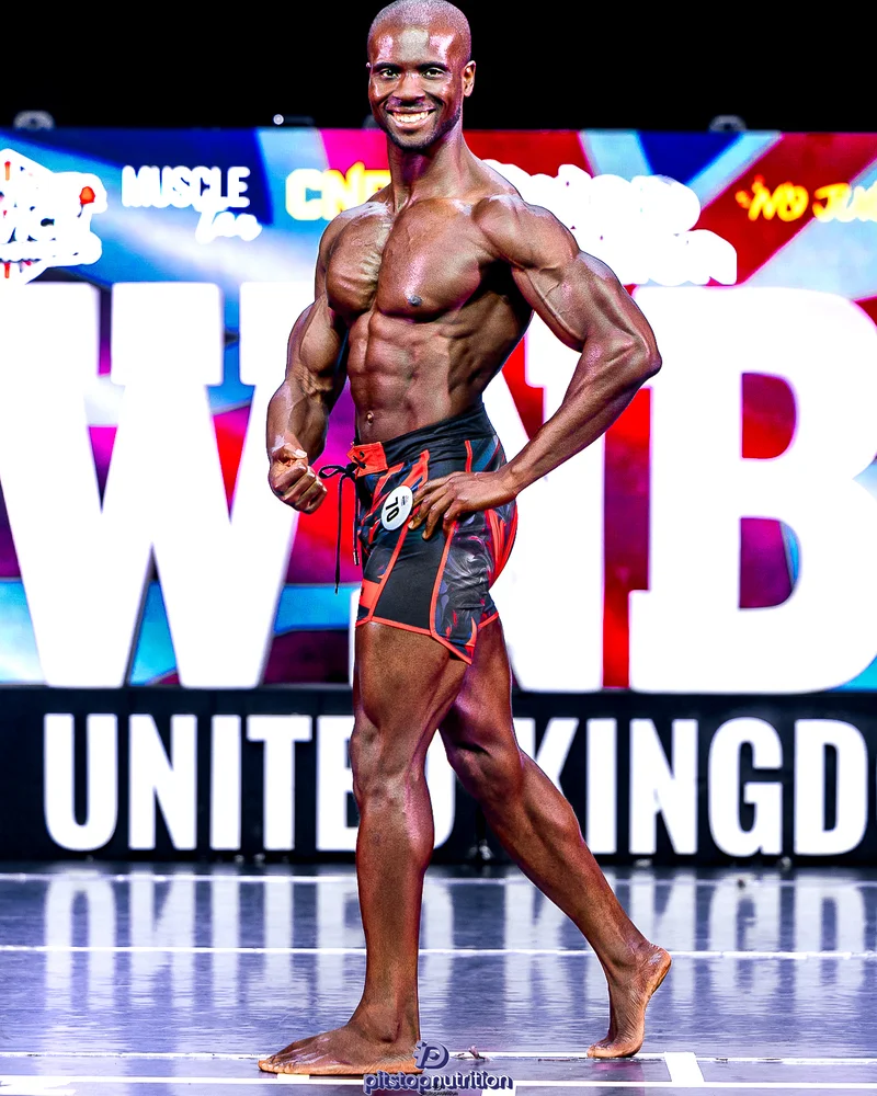 Femi posing on stage at WNBF
