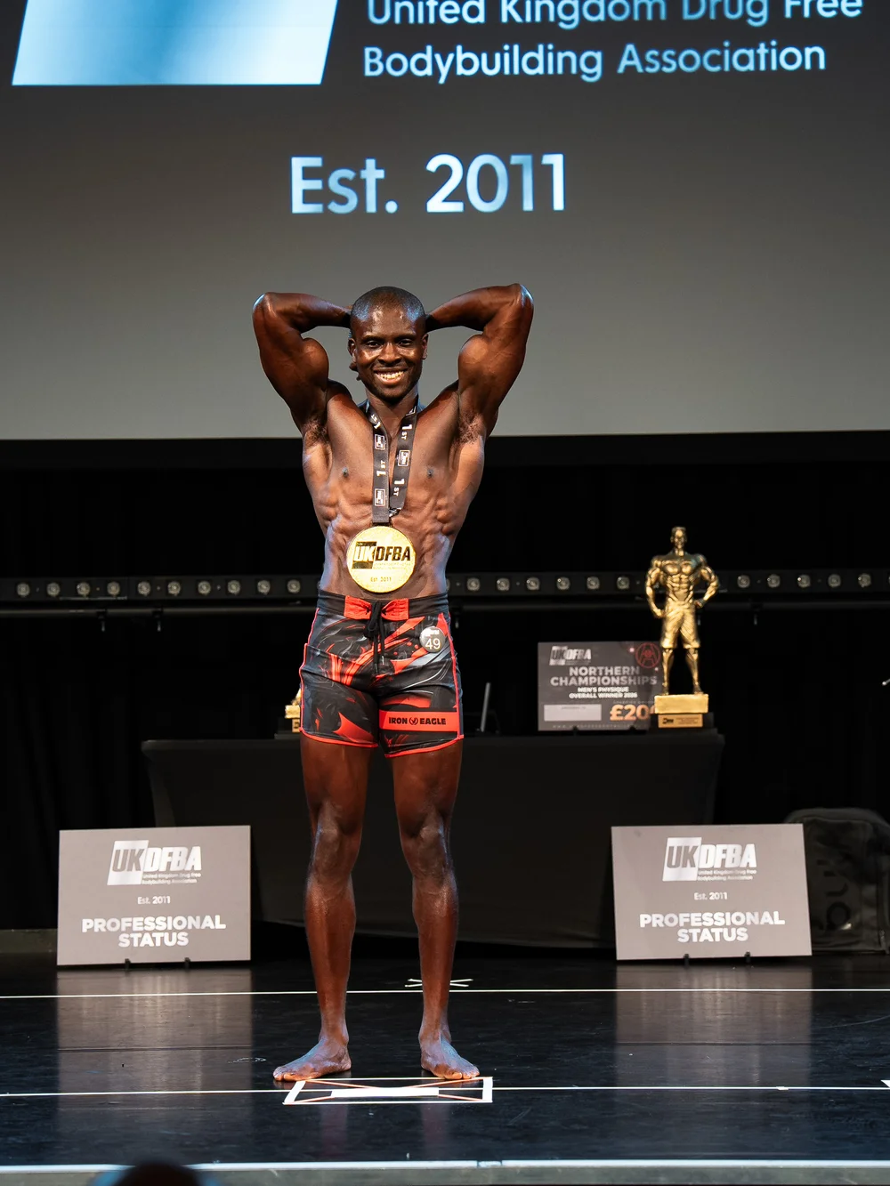 Femi on stage celebrating a UKDFBA title win